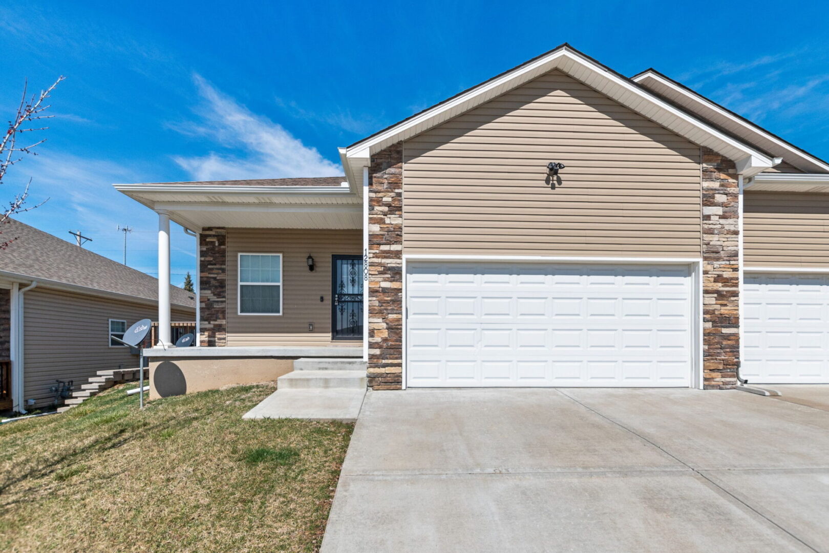 A house with a garage and driveway in front of it.