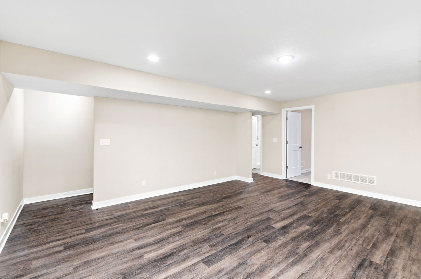 A room with hard wood floors and white walls.