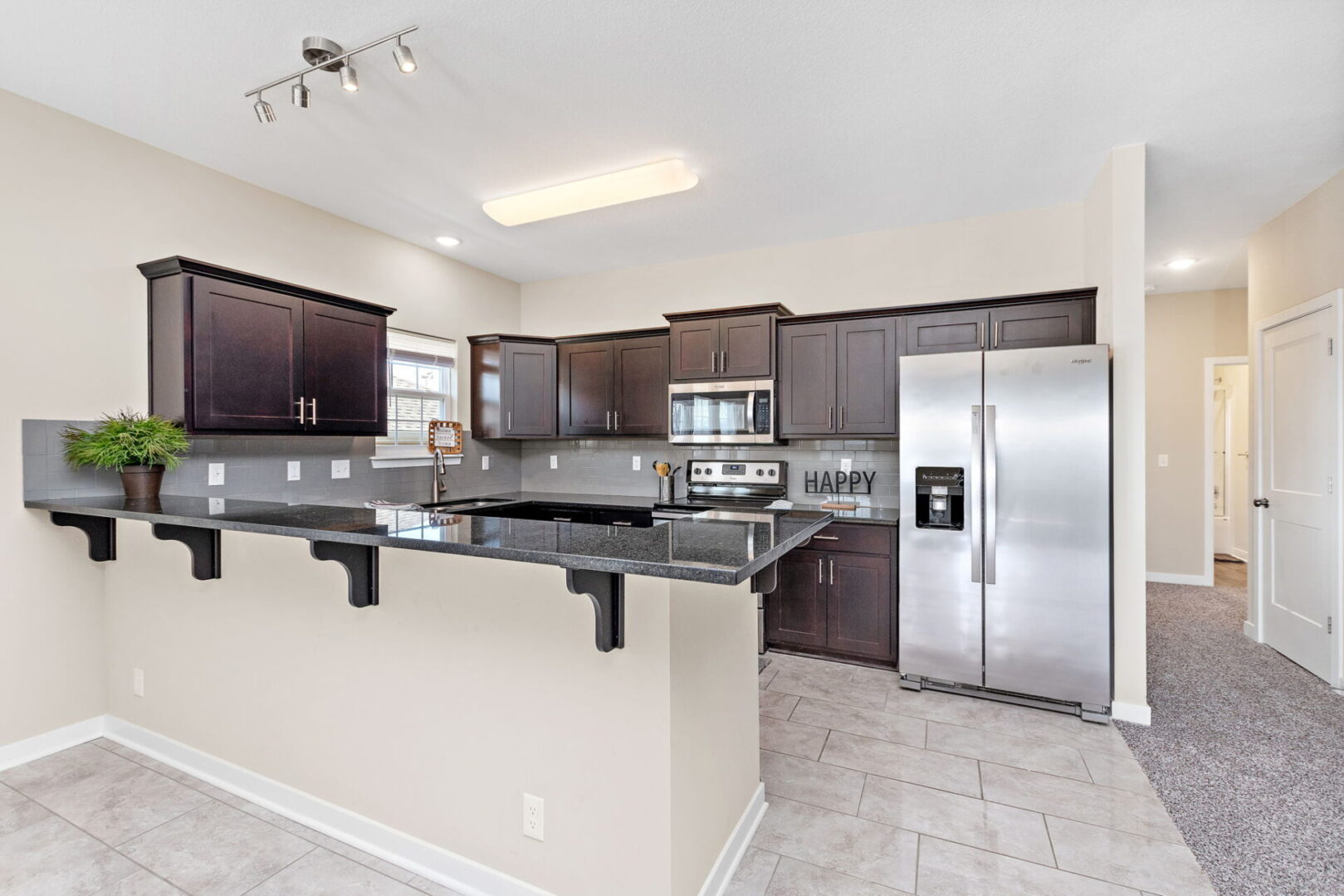 A kitchen with stainless steel appliances and dark wood cabinets.