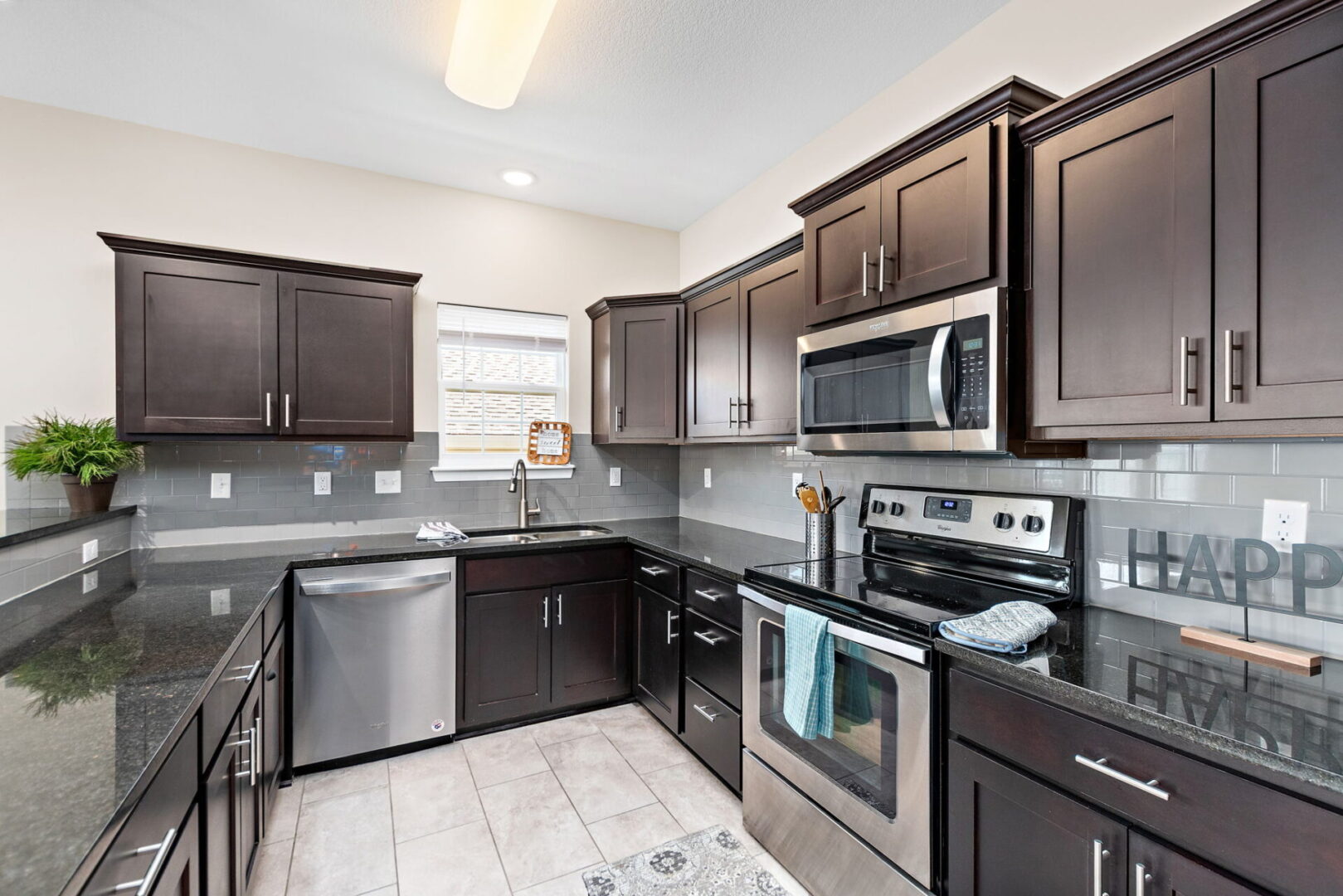 A kitchen with dark wood cabinets and stainless steel appliances.