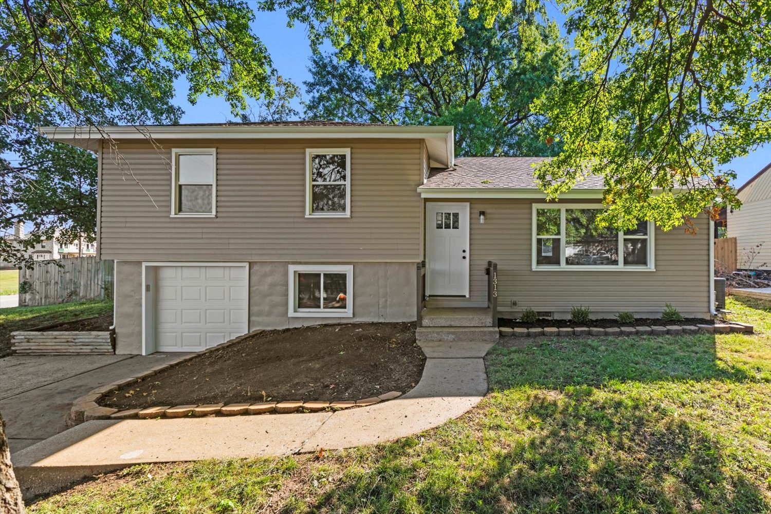 A house with a driveway and steps leading to the front door.