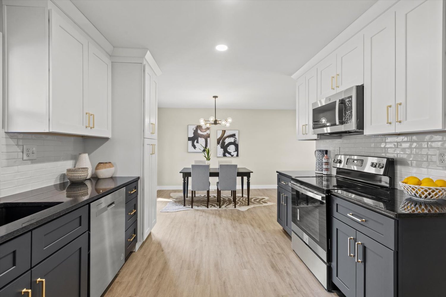 A kitchen with white cabinets and black appliances.