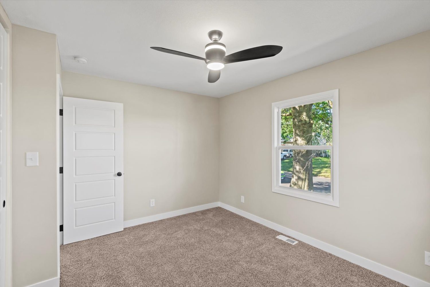 A bedroom with a ceiling fan and a window.