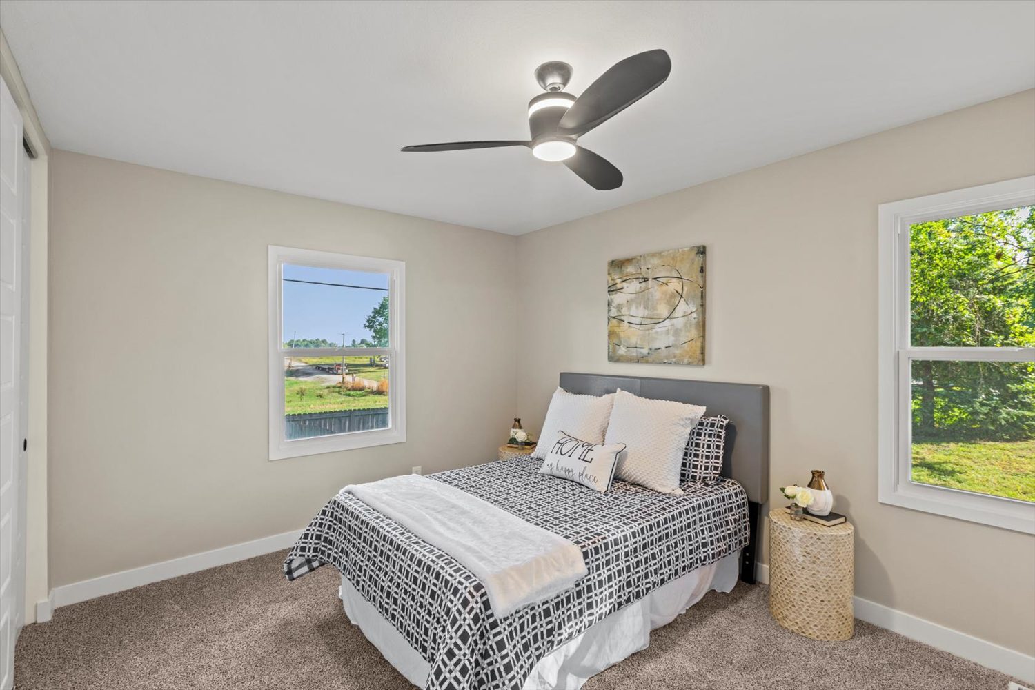 A bedroom with a bed, ceiling fan and window.