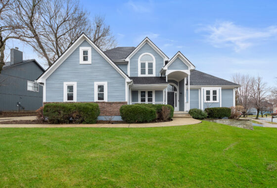 A blue house with green grass in front of it.