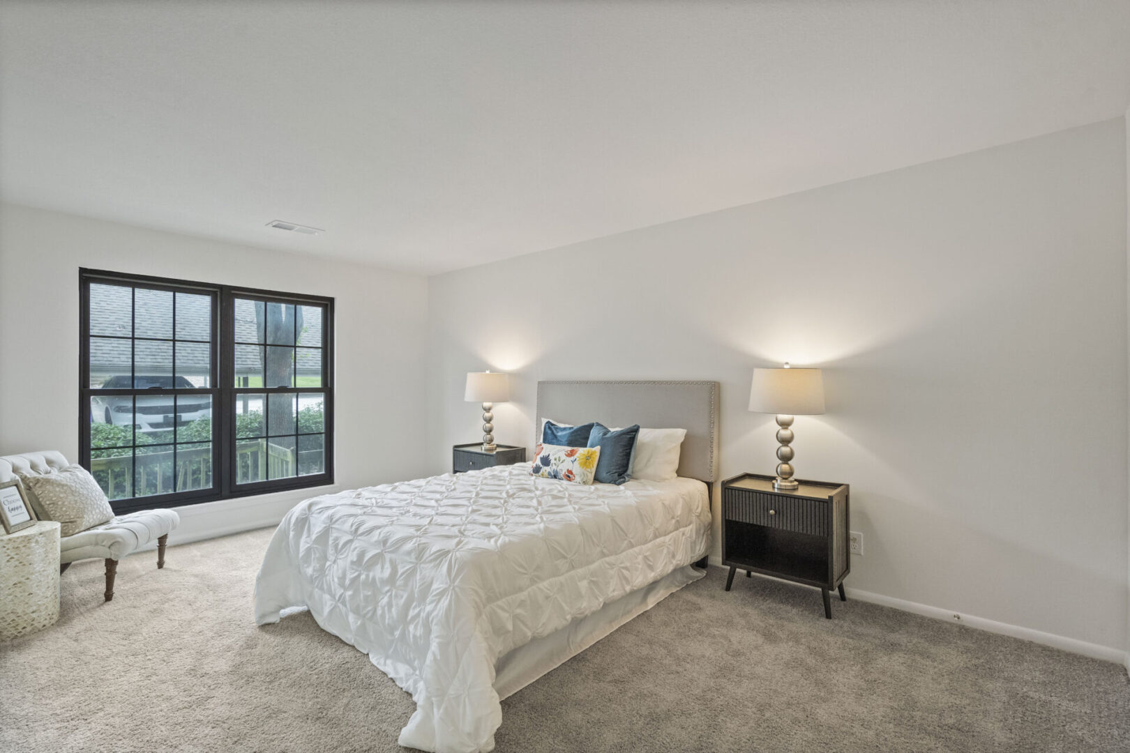 A bedroom with a bed, nightstands and two lamps.