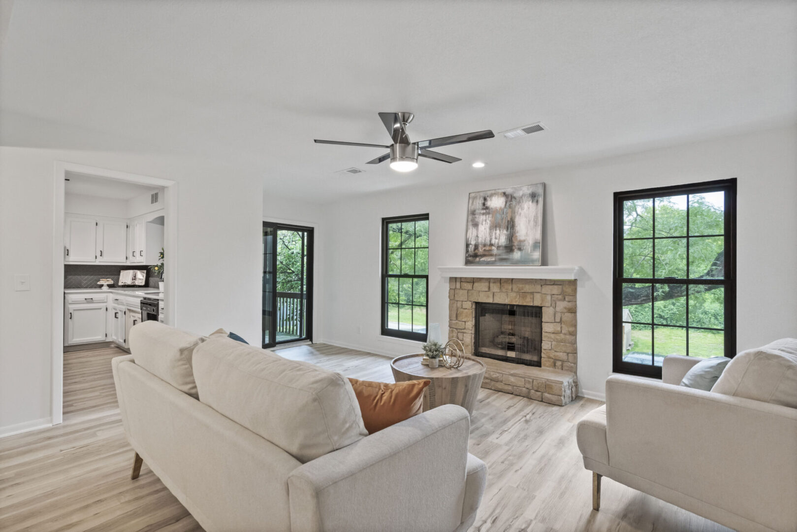 A living room with white furniture and a fireplace.